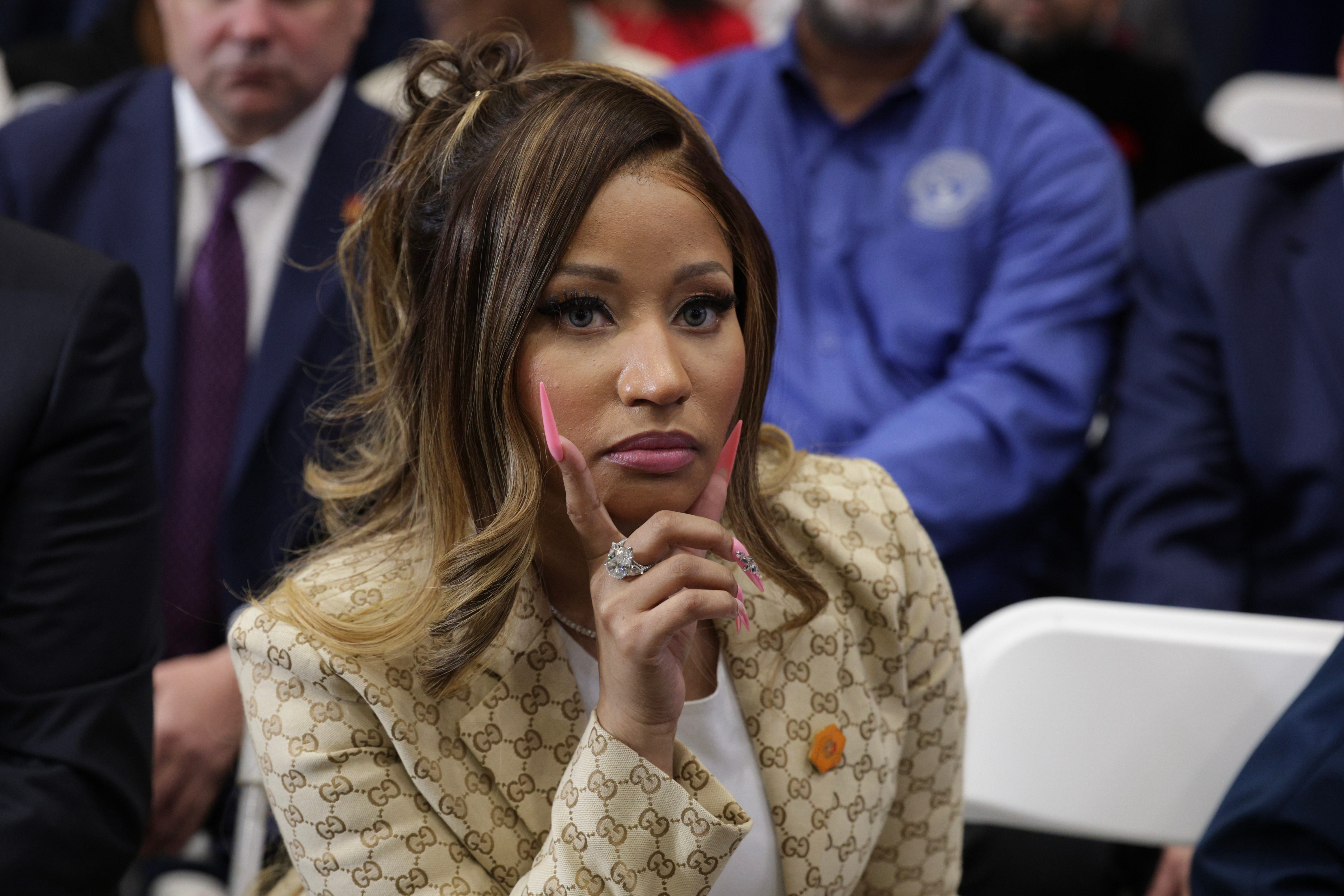 Nicki Minaj listens with her hand near her face, in the photograph accompanying the AOL article.