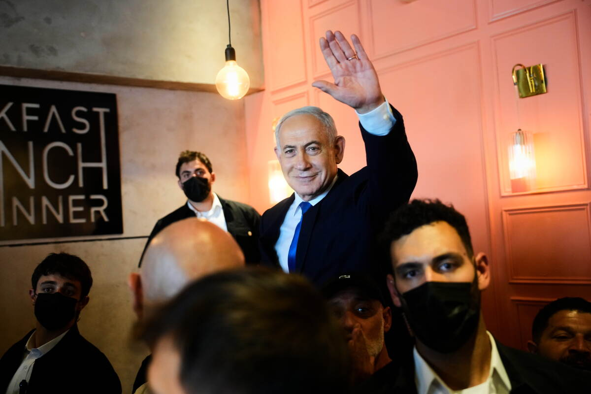 Netanyahu waves in AP’s election-preview photograph.