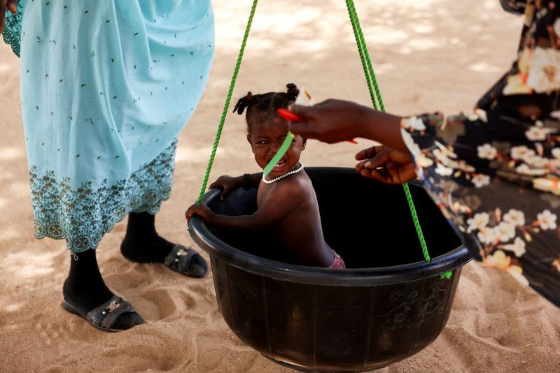 A Sudanese refugee child is screened for malnutrition.